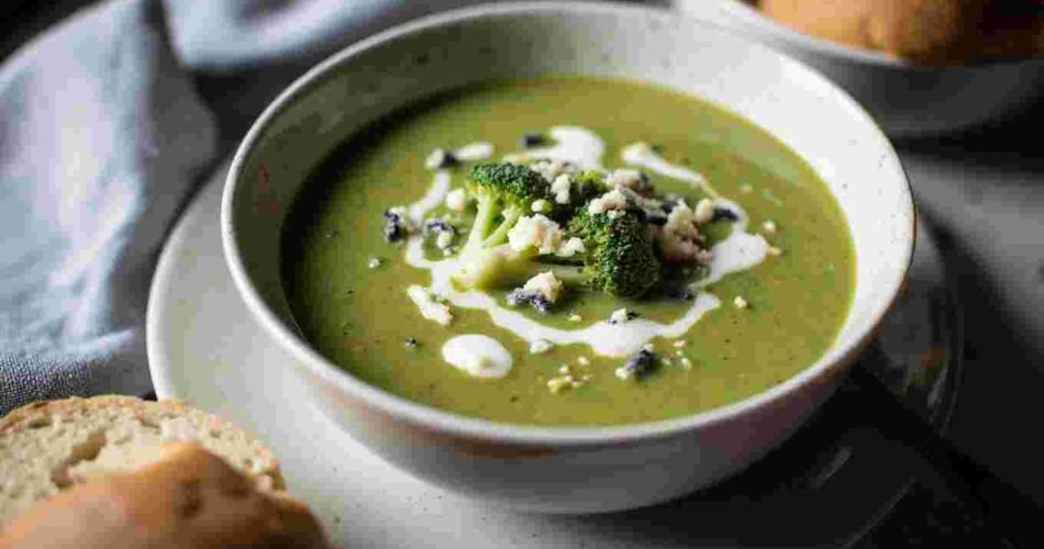 A bowl of creamy broccoli and stilton soup, topped with cheese crumbles.